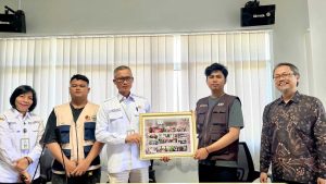 Ketua kelompok mahasiswa KKN menyerahkan kenang-kenangan berupa bingkai dokumentasi kegiatan kepada Lurah Sepinggan Raya Arifuddin, disaksikan Sekretaris Lurah Mediatri dan DPL Subur Anugerah, di Kantor Kelurahan Sepinggan Raya, Rabu (26/8/2026).